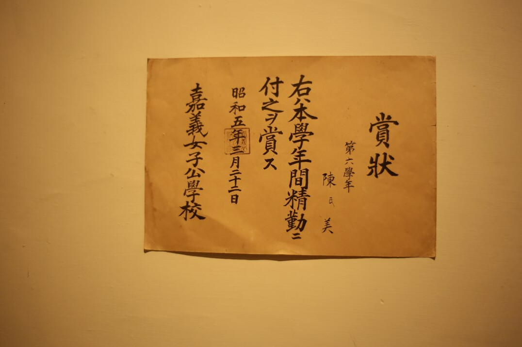 Old yellowed documents and photographs spread on a wooden desk